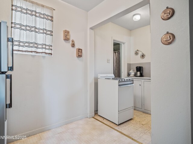 3790 Stewart Way S, Lake Tahoe, CA 96150 - kitchen with white range with gas stovetop, light flooring, white cabinetry, light countertops, and baseboards