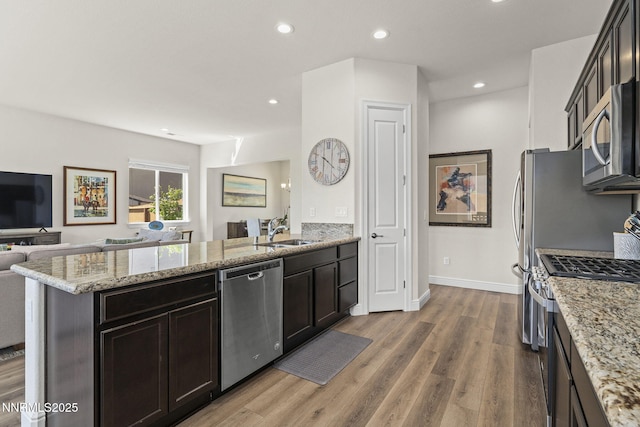 910 Cranfield Ct, Reno, NV 89506 - kitchen with appliances with stainless steel finishes, open floor plan, a peninsula, a sink, and wood finished floors