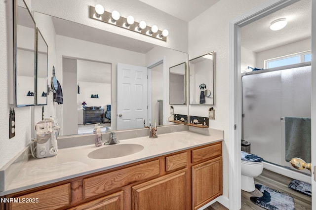 17533 Javalina Ct, Reno, NV 89508 - full bathroom featuring toilet, vanity, a stall shower, and wood finished floors