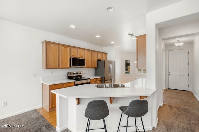469 N Sand Crane Cir, Sparks, NV 89436 - kitchen with appliances with stainless steel finishes, a sink, a kitchen bar, a peninsula, and recessed lighting