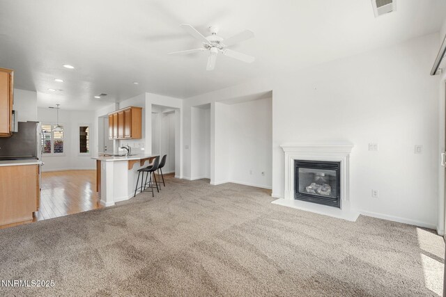 469 N Sand Crane Cir, Sparks, NV 89436 - living room with light carpet, a ceiling fan, recessed lighting, a glass covered fireplace, and baseboards