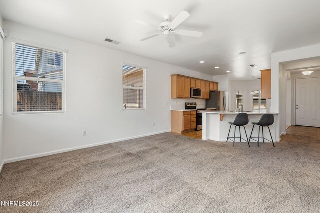 469 N Sand Crane Cir, Sparks, NV 89436 - kitchen featuring stainless steel appliances, a kitchen breakfast bar, baseboards, light carpet, and light countertops