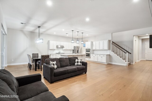 15058 Iron River Dr, Reno, NV 89521 - living room with stairway, recessed lighting, light wood-type flooring, and baseboards
