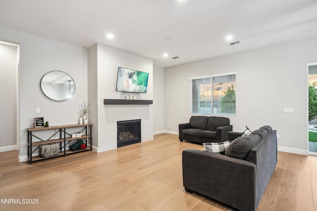 15058 Iron River Dr, Reno, NV 89521 - living area featuring a glass covered fireplace, recessed lighting, light wood-style floors, and baseboards