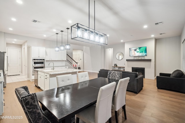 15058 Iron River Dr, Reno, NV 89521 - dining space with recessed lighting, light wood-style flooring, a fireplace, and baseboards