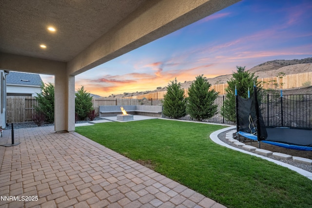 15058 Iron River Dr, Reno, NV 89521 - view of yard featuring a trampoline, a patio, an outdoor fire pit, and a mountain view