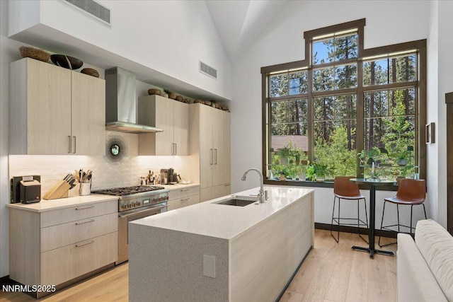 33 Beach Club Dr Unit 506, Stateline, NV 89449 - kitchen featuring wall chimney exhaust hood, high end stainless steel range, modern cabinets, decorative backsplash, and high vaulted ceiling