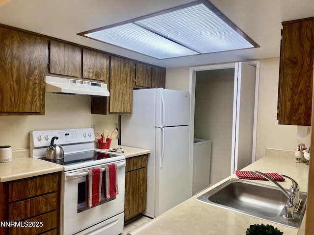 555 E Patriot Blvd, Reno, NV 89511 - kitchen featuring white appliances, under cabinet range hood, a sink, washer / dryer, and light countertops