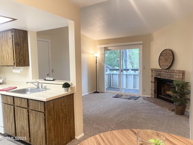 555 E Patriot Blvd, Reno, NV 89511 - kitchen featuring a sink, light colored carpet, light countertops, baseboards, and a brick fireplace