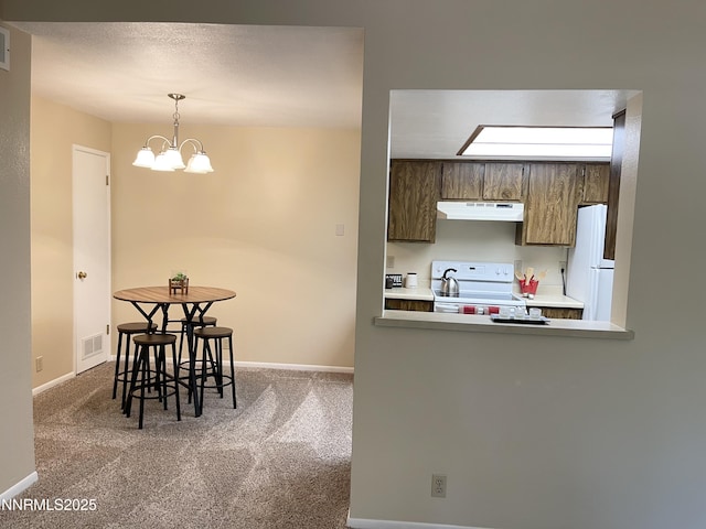 555 E Patriot Blvd, Reno, NV 89511 - kitchen featuring under cabinet range hood, white appliances, carpet flooring, baseboards, and a chandelier