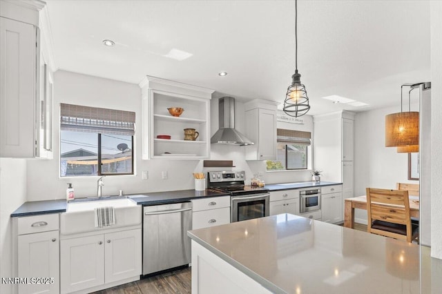 7620 Essex Way, Reno, NV 89506 - kitchen with stainless steel appliances, wall chimney exhaust hood, white cabinets, and recessed lighting