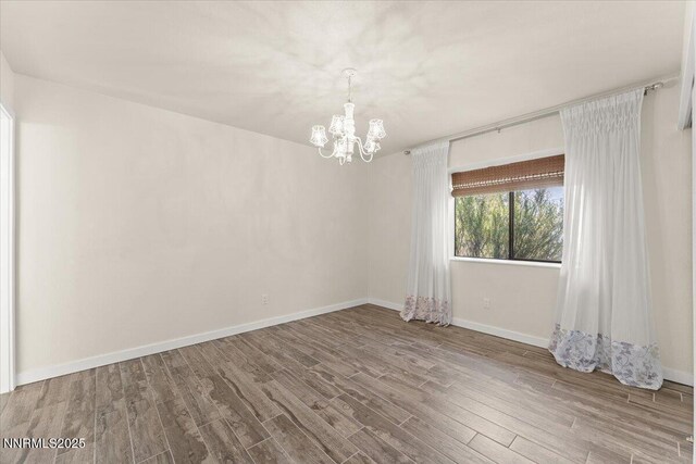 7620 Essex Way, Reno, NV 89506 - empty room featuring a chandelier, wood finished floors, and baseboards