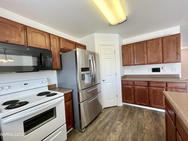 935 Lonnie Ln, Winnemucca, NV 89445 - kitchen featuring white range with electric cooktop, black microwave, stainless steel refrigerator with ice dispenser, dark wood-style flooring, and brown cabinets