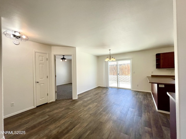 935 Lonnie Ln, Winnemucca, NV 89445 - unfurnished dining area with a chandelier, dark wood-style floors, and baseboards