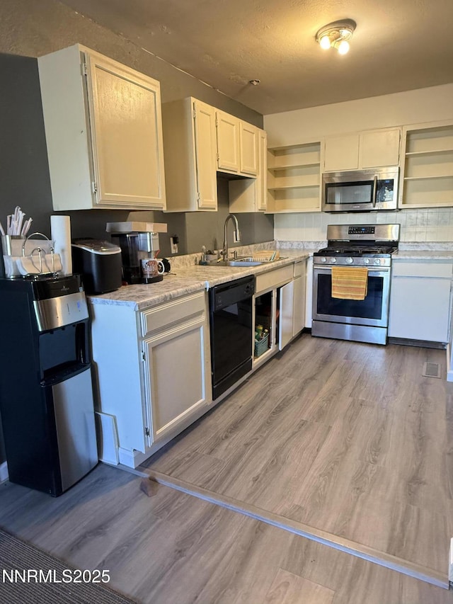 540 Anthony Ln, Fallon, NV 89406 - kitchen featuring stainless steel appliances, open shelves, light wood-style floors, and white cabinetry