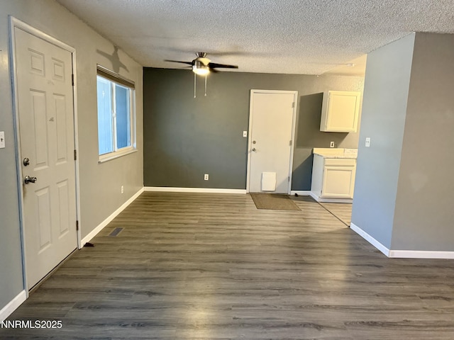 540 Anthony Ln, Fallon, NV 89406 - unfurnished living room featuring a ceiling fan, a textured ceiling, and dark wood finished floors