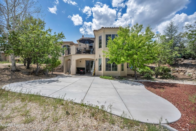 14210 Wild Quail Ct, Reno, NV 89511 - back of property featuring a balcony, stucco siding, driveway, a tiled roof, and a carport