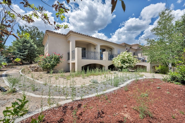 14210 Wild Quail Ct, Reno, NV 89511 - rear view of house with stucco siding, a tiled roof, and a balcony