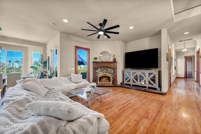 14210 Wild Quail Ct, Reno, NV 89511 - living room featuring recessed lighting, wood finished floors, a ceiling fan, and a warm lit fireplace