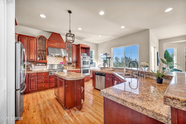 14210 Wild Quail Ct, Reno, NV 89511 - kitchen featuring stainless steel appliances, under cabinet range hood, a spacious island, light wood finished floors, and recessed lighting