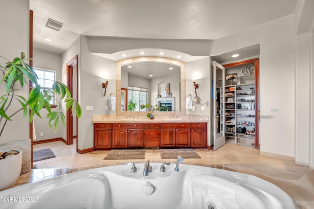 14210 Wild Quail Ct, Reno, NV 89511 - bathroom with double vanity, plenty of natural light, a jetted tub, a spacious closet, and recessed lighting