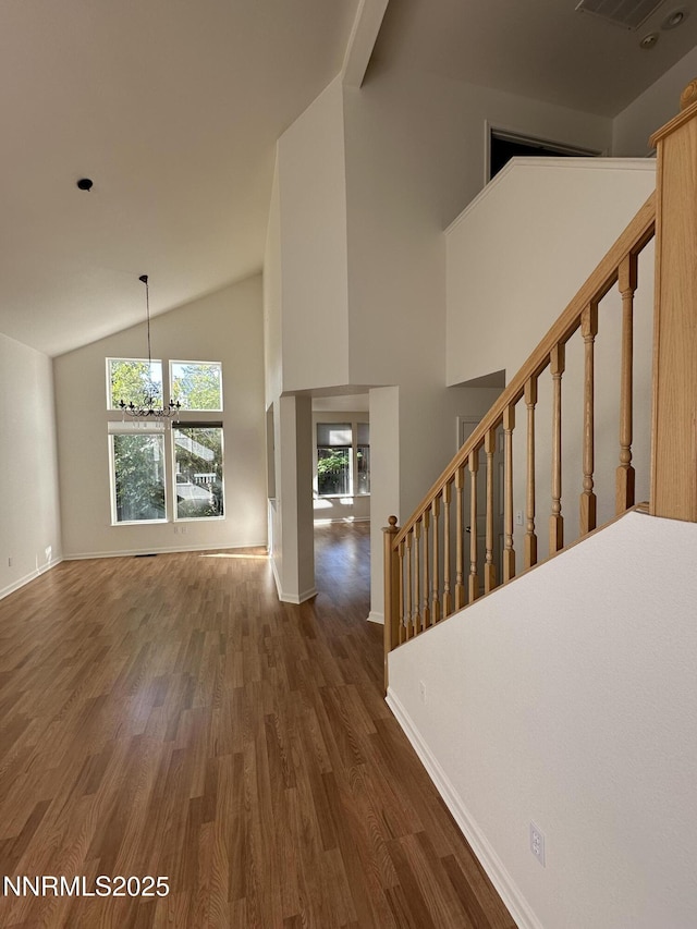 4748 Cedarhill Ln, Reno, NV 89519 - unfurnished living room featuring wood finished floors, plenty of natural light, baseboards, stairs, and high vaulted ceiling