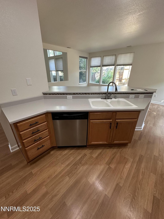 4748 Cedarhill Ln, Reno, NV 89519 - kitchen featuring stainless steel dishwasher, a sink, light wood-type flooring, light countertops, and a textured ceiling