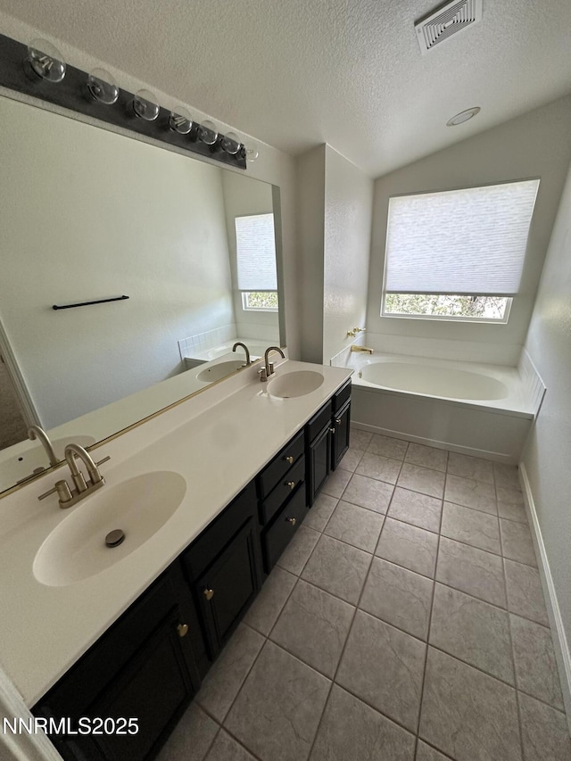 4748 Cedarhill Ln, Reno, NV 89519 - full bathroom with a textured ceiling, a garden tub, tile patterned floors, double vanity, and baseboards