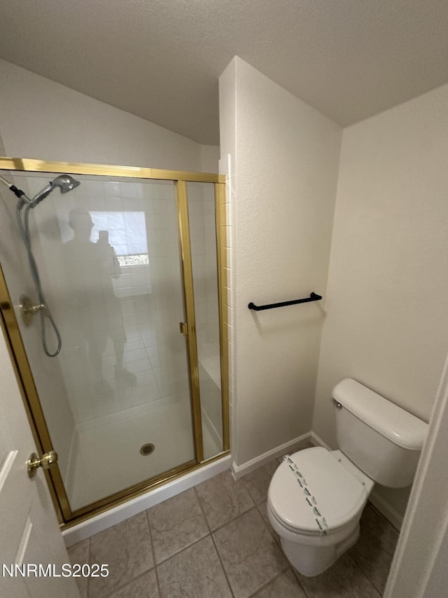 4748 Cedarhill Ln, Reno, NV 89519 - bathroom featuring toilet, a stall shower, lofted ceiling, tile patterned flooring, and baseboards