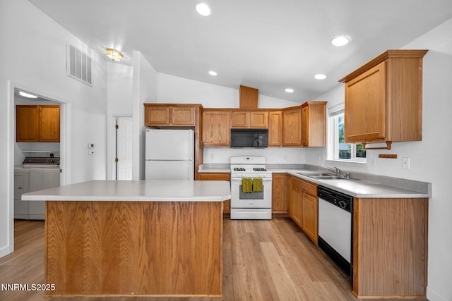 1409 Aldersgate Ct, Gardnerville, NV 89410 - kitchen featuring white appliances, vaulted ceiling, a sink, washing machine and dryer, and light wood-type flooring