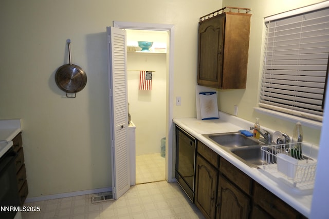 461 Debbie Dr, Walker Lake, NV 89415 - kitchen featuring light flooring, dishwasher, a sink, light countertops, and dark brown cabinetry