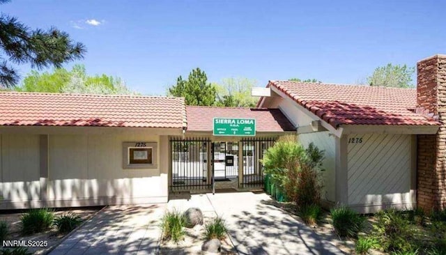 1169 Wagon Wheel Cir, Reno, NV 89503 - entrance to property with a gate, a chimney, and a tile roof