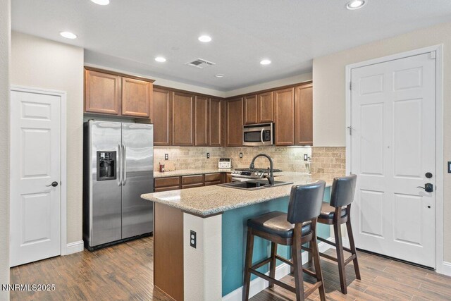 1955 Wind Ranch Rd Unit A, Reno, NV 89521 - kitchen with appliances with stainless steel finishes, wood finished floors, backsplash, a kitchen breakfast bar, and a peninsula
