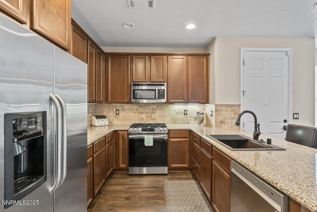1955 Wind Ranch Rd Unit A, Reno, NV 89521 - kitchen with appliances with stainless steel finishes, a sink, dark wood-type flooring, light stone counters, and backsplash