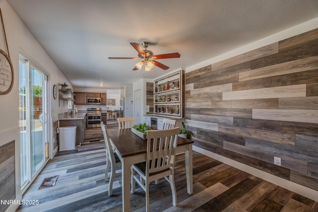 18105 Pasado Ct, Reno, NV 89508 - dining room featuring wooden walls, dark wood-style flooring, and ceiling fan