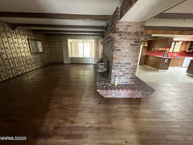 3411 San Juan Dr, Reno, NV 89509 - unfurnished living room with hardwood / wood-style floors, beam ceiling, healthy amount of natural light, and a textured ceiling