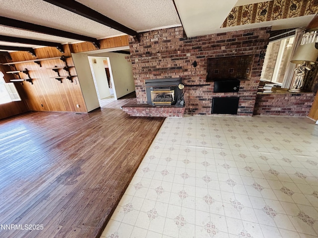 3411 San Juan Dr, Reno, NV 89509 - unfurnished living room with a textured ceiling, wood walls, beam ceiling, and a fireplace