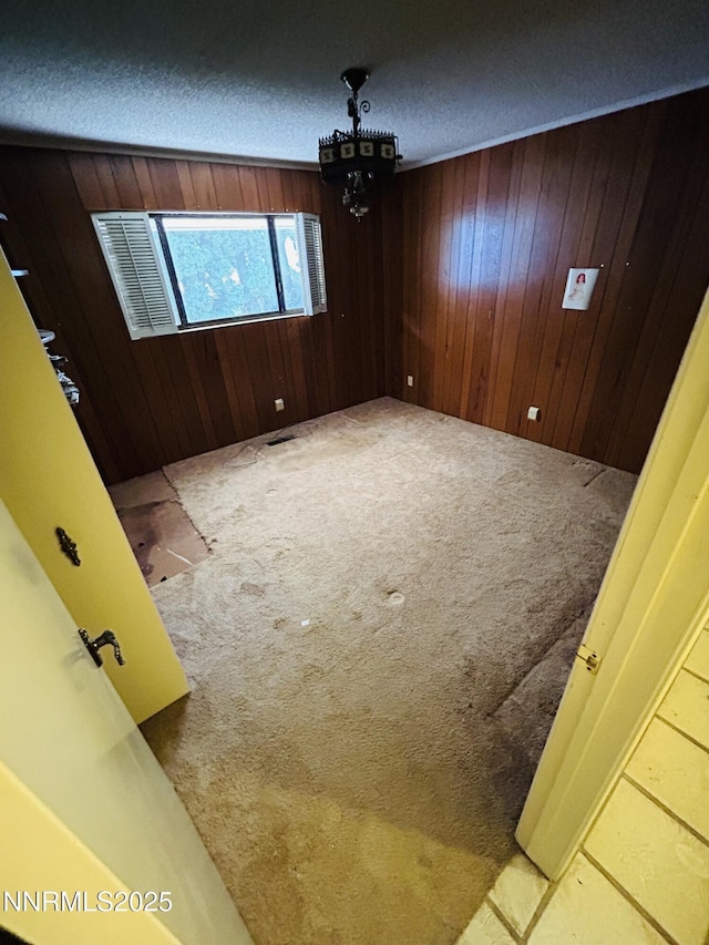 3411 San Juan Dr, Reno, NV 89509 - spare room with carpet, wooden walls, a chandelier, and a textured ceiling