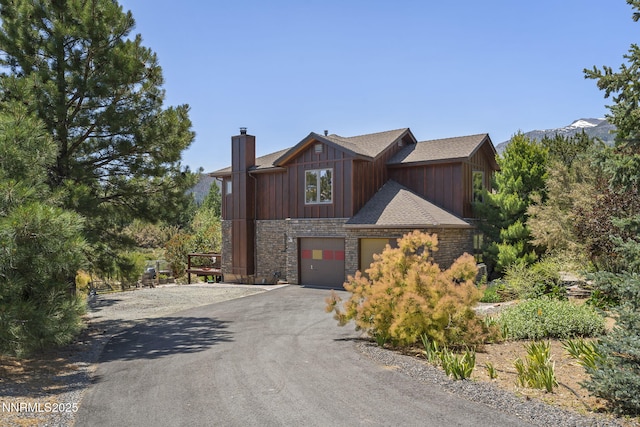 16460 Jefte Ct, Reno, NV 89511 - view of front of property featuring asphalt driveway, a chimney, stone siding, board and batten siding, and a garage