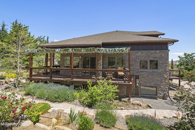 16460 Jefte Ct, Reno, NV 89511 - back of house featuring a deck, board and batten siding, stone siding, and a shingled roof