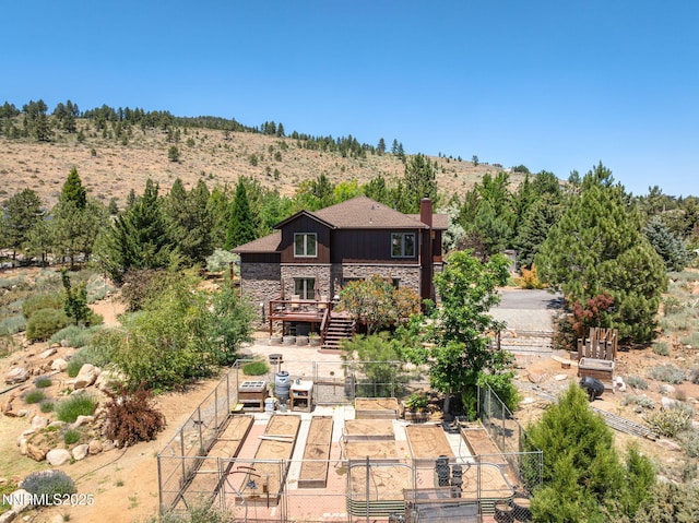 16460 Jefte Ct, Reno, NV 89511 - rear view of property featuring stone siding, a chimney, and a wooden deck