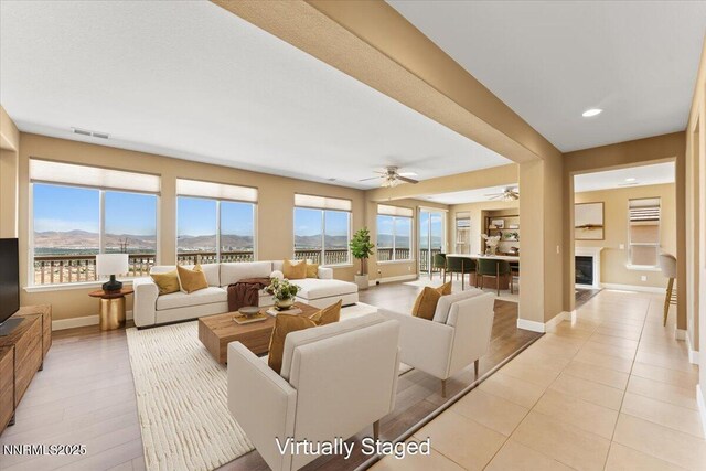 1080 S University Park Loop, Reno, NV 89512 - living room with a ceiling fan, baseboards, healthy amount of natural light, a glass covered fireplace, and recessed lighting