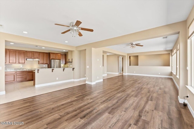 1080 S University Park Loop, Reno, NV 89512 - unfurnished living room featuring a ceiling fan, baseboards, light wood-style flooring, and recessed lighting
