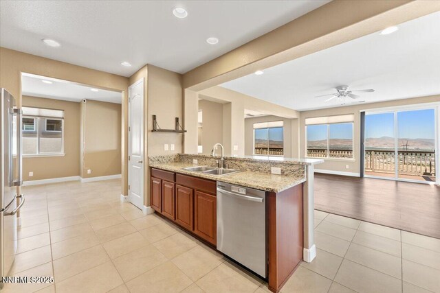 1080 S University Park Loop, Reno, NV 89512 - kitchen with stainless steel appliances, a sink, ceiling fan, light tile patterned floors, and healthy amount of natural light