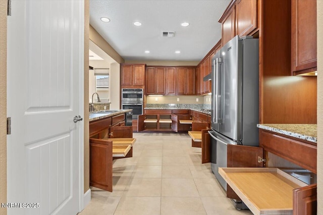 1080 S University Park Loop, Reno, NV 89512 - kitchen with appliances with stainless steel finishes, a sink, recessed lighting, light tile patterned floors, and light stone counters