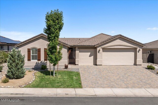1080 S University Park Loop, Reno, NV 89512 - ranch-style home with stucco siding, an attached garage, decorative driveway, a tile roof, and a front yard