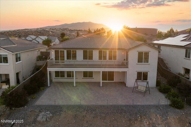 1080 S University Park Loop, Reno, NV 89512 - back of property at dusk with a mountain view, a patio, a tile roof, and stucco siding