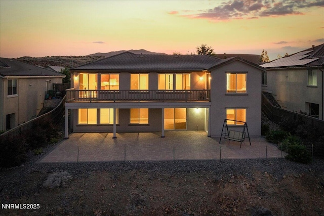 1080 S University Park Loop, Reno, NV 89512 - back of property at dusk with a patio, stucco siding, and a tiled roof