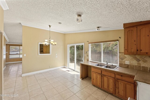 779 E York Way, Sparks, NV 89434 - kitchen featuring a sink, crown molding, a chandelier, decorative light fixtures, and light tile patterned floors