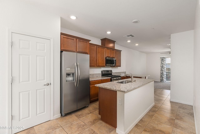 3002 Sterling Ridge Cir, Sparks, NV 89431 - kitchen featuring appliances with stainless steel finishes, a sink, a center island with sink, brown cabinetry, and light stone counters
